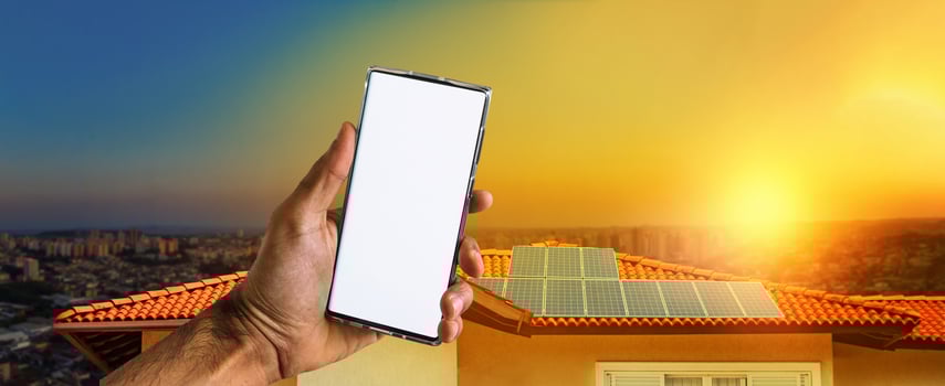 Male hands holding a mobile with solar energy photovoltaic panel at background. Space for text photo