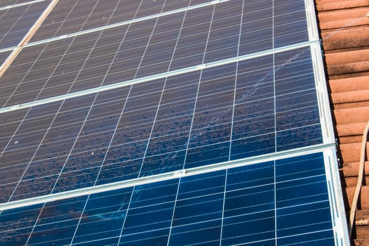 Solar worker cleaning photovoltaic panels with brush and water. Photovoltaic cleaning, before and after concept image. Space for text. photo