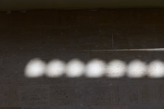 Dappled sunlight creates a dreamy pattern on a textured wall in the early afternoon photo