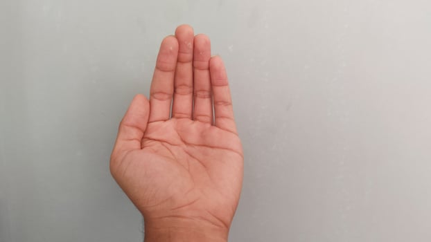 a person's hand on a gray background photo