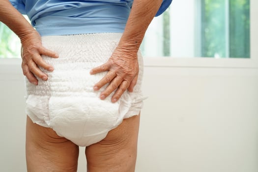 Asian senior woman patient wearing adult incontinence diaper pad in hospital. photo