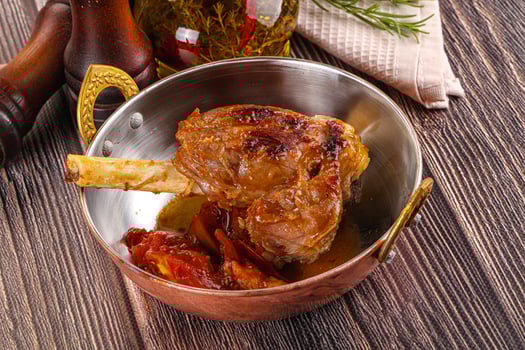 Baked lamb shank with vegetables photo