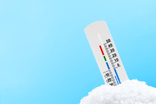 Thermometer Measuring Cold Temperature in Snow against blue background photo