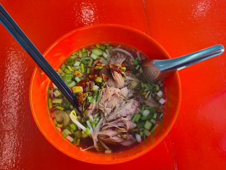 Street food in Thailand Noodles in a red bowl on a red background photo