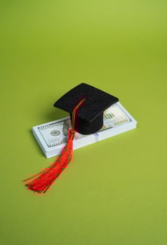 A stack of money and a graduation cap. Concept of a loan for education. Educational grants. Student loan concept. Educational grants. Unaffordable and expensive. High paying jobs. photo