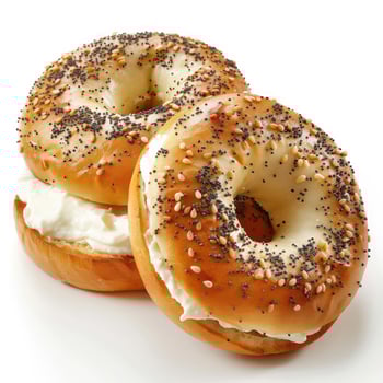 Golden brown bagels with sesame seeds on top, topped with cream cheese and served in a light brown napkin. photo