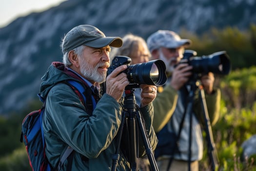 Senior nature photographers taking pictures on mountain with telephoto lenses photo