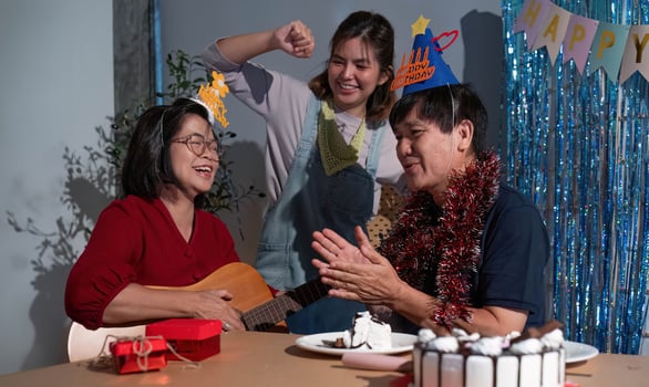 A man and two women are celebrating a birthday photo