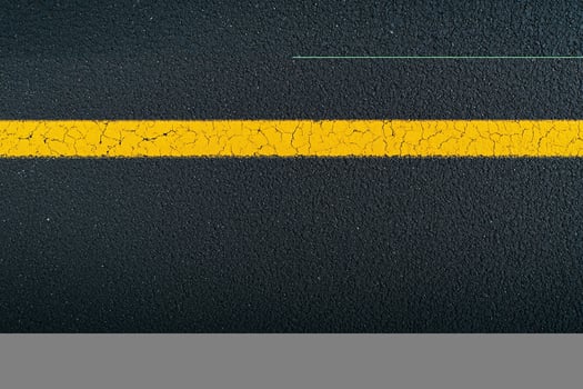 A yellow line on the asphalt with a black background photo