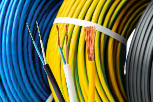 Closeup of Stripped Electrical Wires Against Rolled Cable photo
