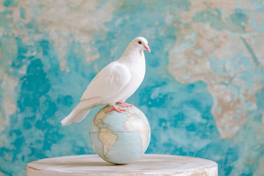 A white dove sits peacefully on a globe against a soft, colorful background representing world unity and peace photo