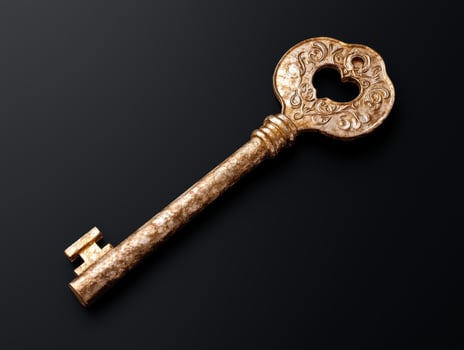 Ornate antique key on black background photo
