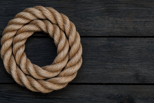 Coiled rope on dark wooden background photo
