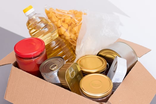 Donation Box of Free Food. Carton Box with Canned Food, Cereals and Grocery. Meal Reserves. Emergency Food Storage in Case of Crisis. Free Social Help, Blessings and Care. Strategic Food Supplies photo