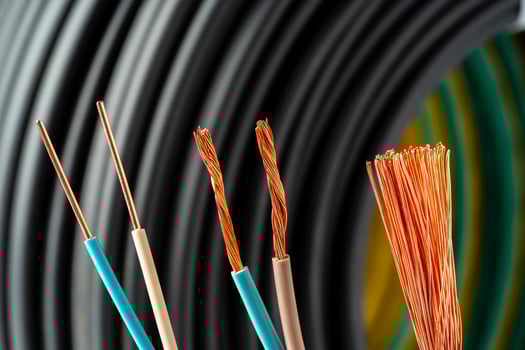Closeup of Stripped Electrical Wires Against Rolled Cable photo