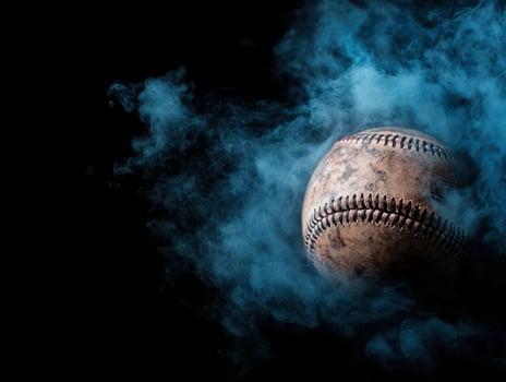 A baseball is in the smoke on a black background photo