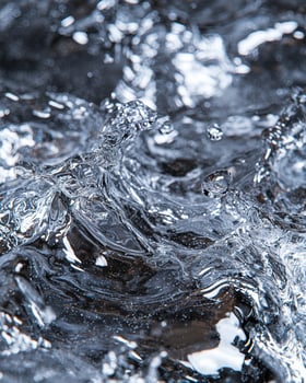 A close up of water splashing on a rock photo