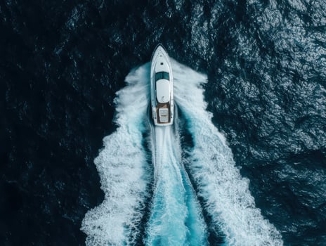 Aerial view of luxury yacht speeding across dark blue ocean photo