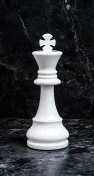 White chess king piece on black marble background photo