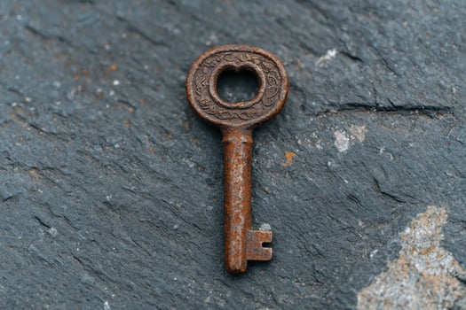 An old rusty key on a stone surface photo