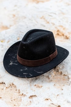 A black hat on a rock with brown leather photo
