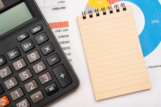 Blank note on desk with monthly budget graph. Financial data analyzing. Working on desk with using calculator, finance accounting. Copy space. photo