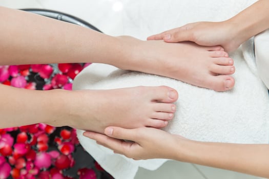 foot massage hand pressing sole spot pain relief feet care beauty cosmetic process in spa salon photo