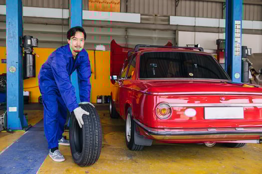 Asian Japanese male mechanic worker portrait in auto service workshop car tyre maintenance center replace fix auto part photo