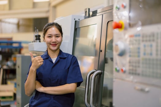 Portrait asian woman worker working in heavy industry machine. Young engineer female happy thumbs up. photo