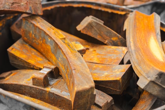 pile of rusty metal pieces used old part of train brake pad garbage rusted steel texture. photo