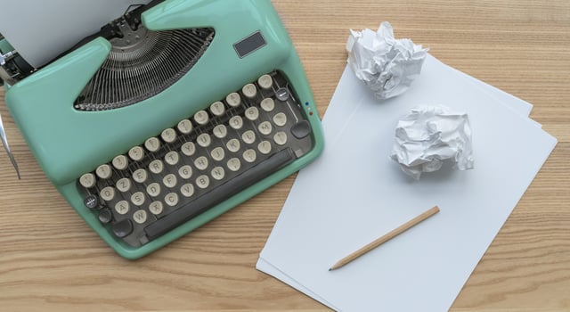 A vintage typewriter with paper sheets, stencil and paper balls. photo