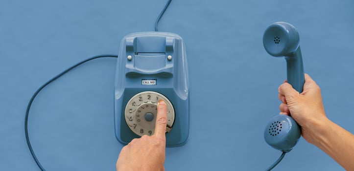 A vintage dial telephone handset with one hand and background. photo