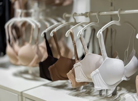 Assorted bra collection display in lingerie store with neutral tones and varied sizes photo