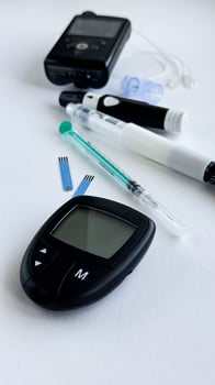 Diabetes monitoring tools, glucometer, insulin pen, insulin pump, test strips, and syringe on white background photo
