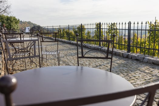Empty Outdoor Cafe Terrace with Iron Furniture and Scenic Morning View. photo