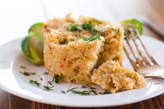 homemade cooked bulgur with Brussel sprouts in a plate, on a wooden table photo