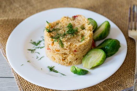 homemade cooked bulgur with Brussel sprouts in a plate, on a wooden table photo
