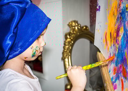 Smiling young boy with paint on his hands and face photo