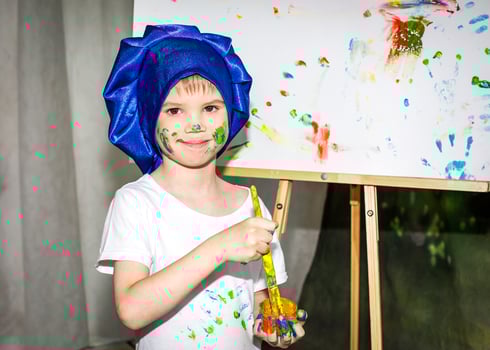 Smiling young boy with paint on his hands and face photo