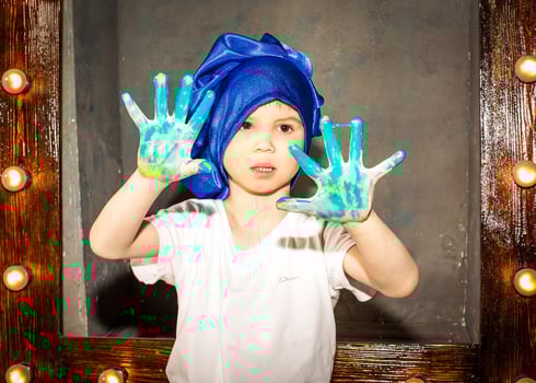 Smiling young boy with paint on his hands and face photo