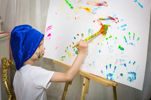 Smiling young boy with paint on his hands and face photo