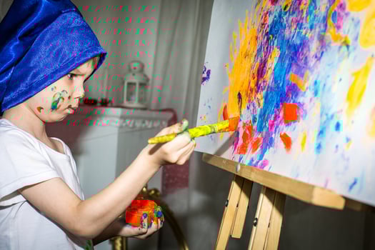 Smiling young boy with paint on his hands and face photo