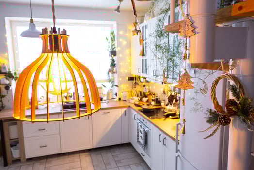 Christmas decor in white kitchen, modern rustic interior with a snowy Christmas tree and gold fairy lights. New Year, Christmas mood, cozy home. photo