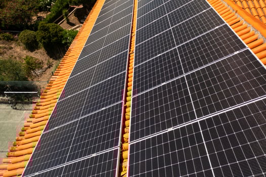 Drone view of house rooftop equipped with solar panels in modern city photo
