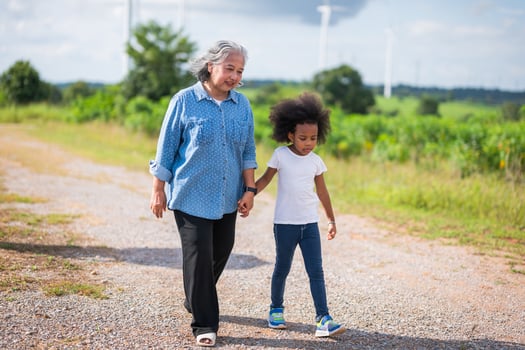 woman and a child are walking together on a dirt road photo
