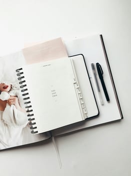 a planner notebook and pen on a white surface photo