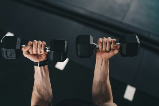 a man is holding two dumbbells in his hands photo