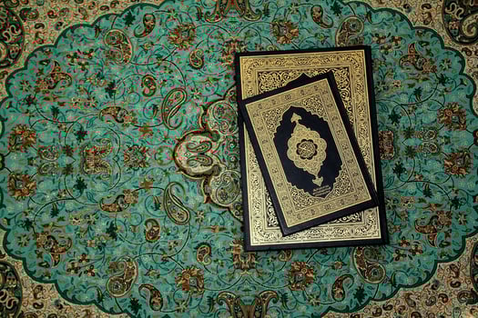a quran on a turquoise rug photo