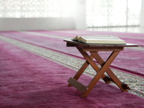 open book on a wooden table in a mosque photo