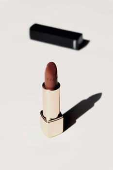 a lipstick sitting on a table with a black box photo